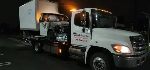 Geer's Towing performing a nighttime recovery of a fire-damaged box truck